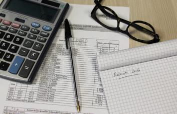 calculatrice, lunettes et bloc note