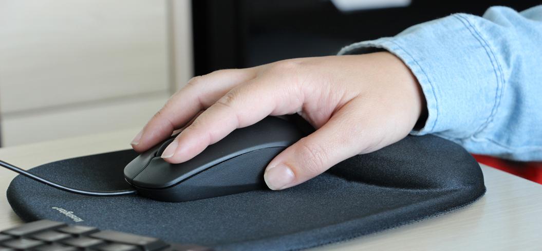 Main sur une souris d'ordinateur